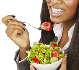 african business woman eating salad and smiling isolated
