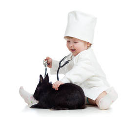 Adorable kid with clothes of doctor. Girl is playing with pet bu