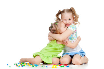 sisters girls playing and embracing over white background