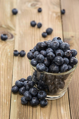 Blueberries in a glass with blurred fruits