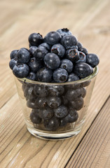 Blueberries in a glass on wood