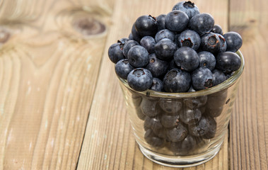 Blueberries in a glass on wood