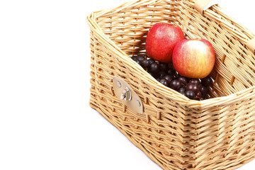Apples and grapes in  wicker basket.