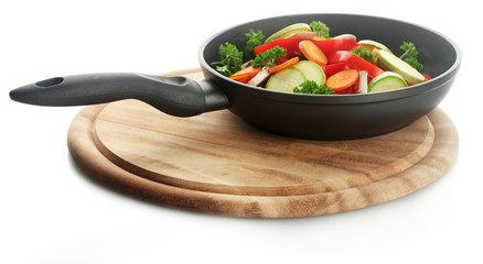 frying pan with vegetables on white