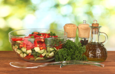 Fresh salad and oil on green background
