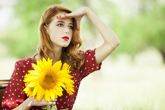 Redhead girl with sunflower at outdoor.
