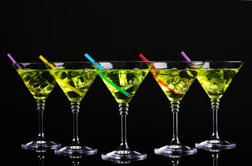 Yellow cocktail in martini glasses isolated on black
