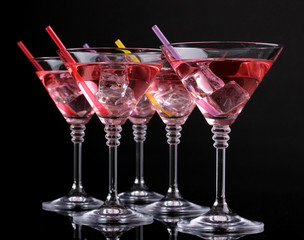 Red cocktail in martini glasses isolated on black