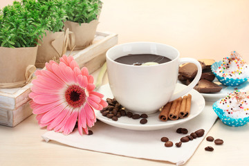 cup of coffee and gerbera  beans, cinnamon sticks