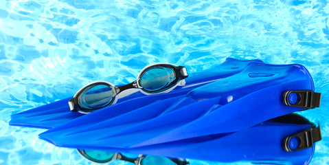 blue flippers and goggles on blue sea background