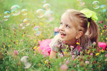 Happy little girl playing with bubbles - Powered by Adobe