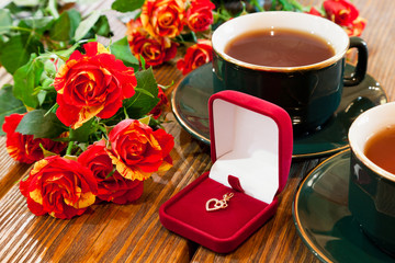 gold jewelry, cups of tea and roses bouquet