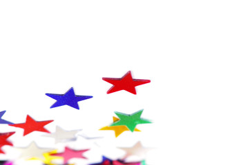 Christmas decoration of colored confetti stars against white bac