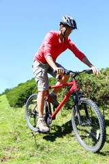 Fototapeta na wymiar Man riding mountain bike in summertime