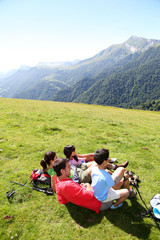 Family laying down the grass enjoying mountain view