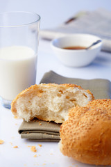 portion loaf with sesame and milk on background