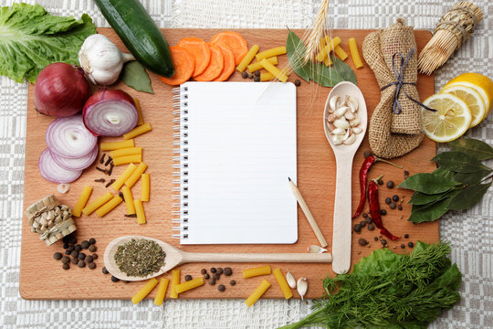 notebook for recipes and spices on wooden table