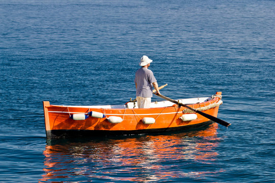 Sailor rowing on wooden taxi boat