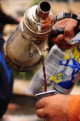a man pours coffee in a plastic cup