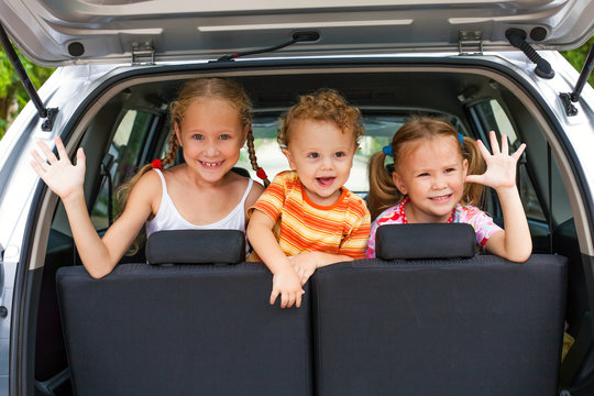 three happy kids in the car