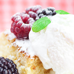 cake with icing,icecream, raspberry, blackberry and mint on a pl