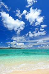 南国沖縄の美しいビーチに打ち寄せる透明な波と夏空