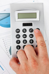 Man's hand with a calculator