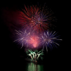 Firework over the water in the night sky