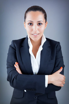 Smiling young business woman on grey background