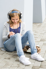Student teenager writing and listening to music