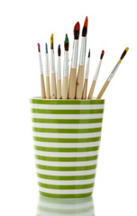 Paint brushes with gouache in cup isolated on white