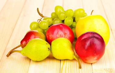 ripe sweet fruits and berries on wooden background