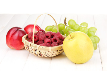 ripe sweet fruits and berries on wooden background