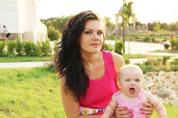 Mother with her baby in spring green field