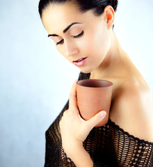 Oryginalna kobieta w bluzce trzymająca w dłoni kubek z herbatą