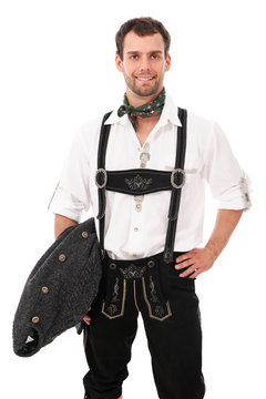 Junger Mann in bayerischer Tracht mit Strickjacke unterm Arm