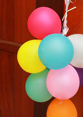 Multicolored balloons hanging on wooden door