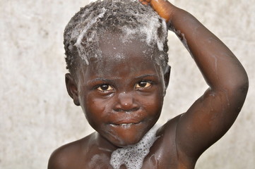 Fototapeta na wymiar Kleines,afrikanisches Mädchen wäscht ihre Haare