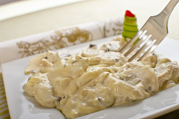 Mushrooms and white garlic sauce on a white plate.