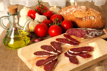 fondo comida mediterránea, fuet, tomates, ajos, pan, aceite de oliva