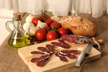 comida mediterránea tradicional  con fuet, pan, tomates, ajos y aceite de oliva virgen extra, fondo horizontal