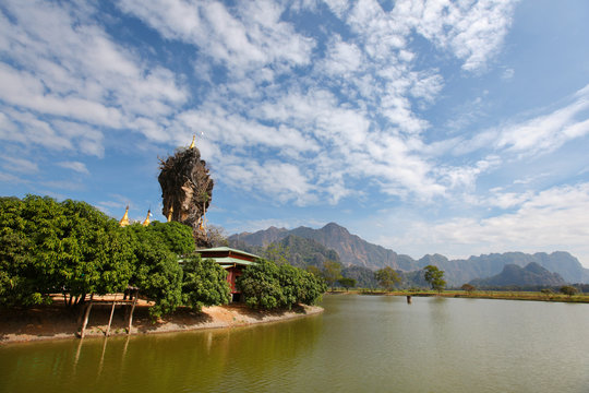 Buddhist pagoda on a rock beside river in Burma,
