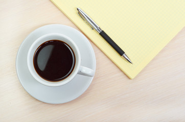 Obraz na płótnie Canvas Coffee cup with note book
