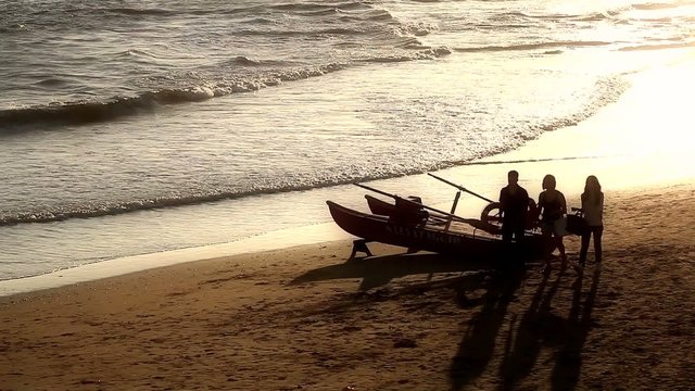 Lifeguard boat and teenager on the beach at sunset