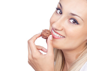 Happy woman eating praline, studio shot