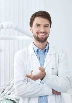 Smiley dentist welcomes the patient