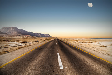 road in desert under the moon