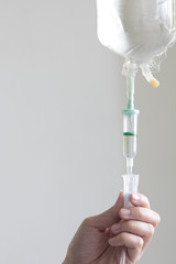 Nurse's hand adjust an IV drip