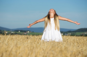 Fototapeta na wymiar Mädchen geniesst die Sonne im Feld