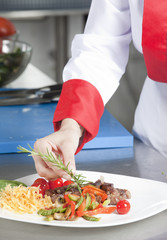 A chief dressed in white holding a white tray  